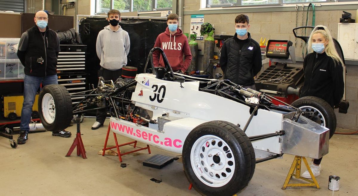 Lecturer and four students pictured behind SERC racing car